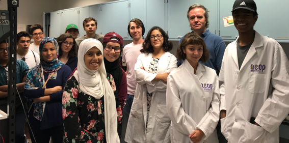 Three REAP students (in lab coats) give a lab tour to a UNM School of Engineering camp last summer.